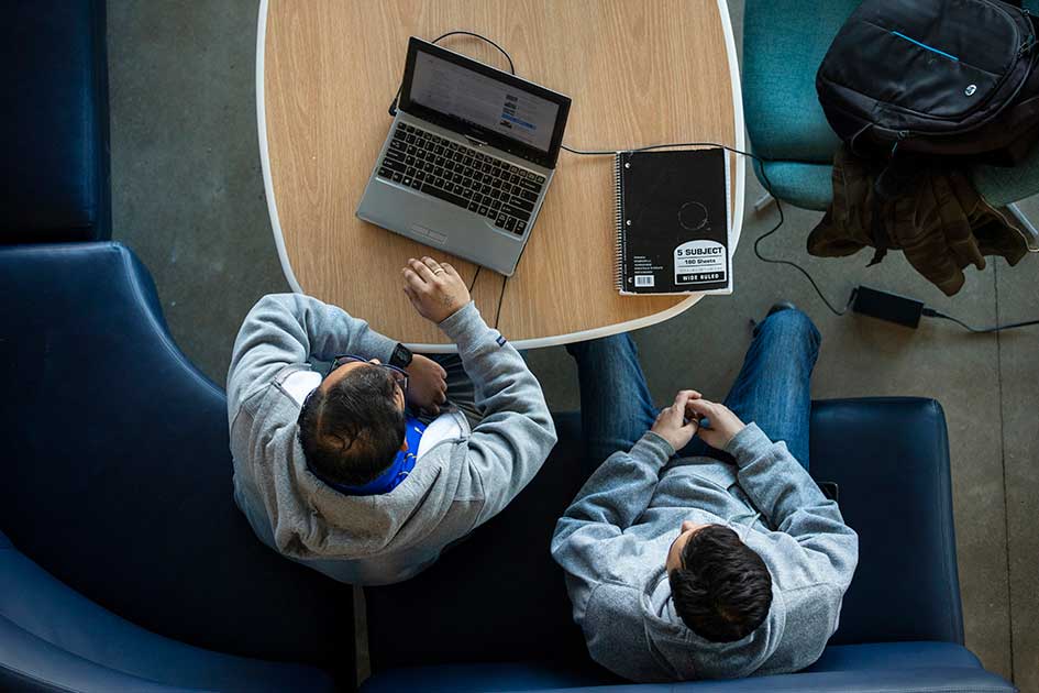 birds eye view of two people with laptops on a table