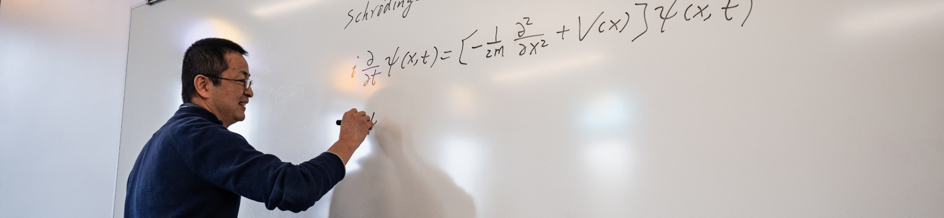 dr. peng guo writing math equations on whiteboard