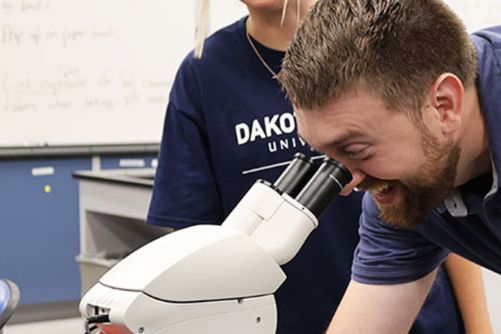 Professor looking through a microscope.