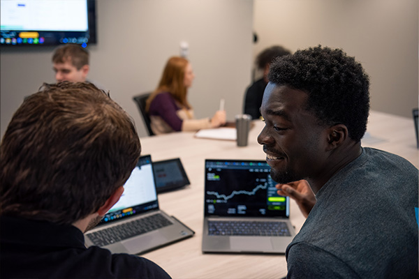 students in front of a computer displaying a graph