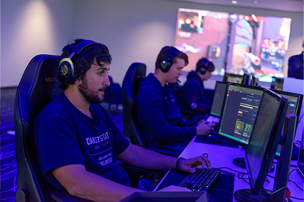 Dakota State's esports team in front of their rigs.