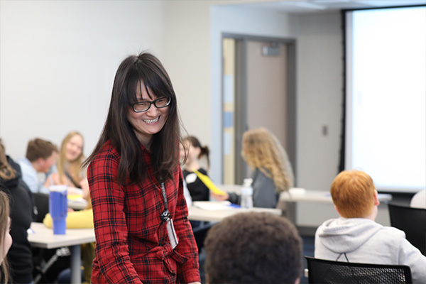 Business professor teaching students with a smile.