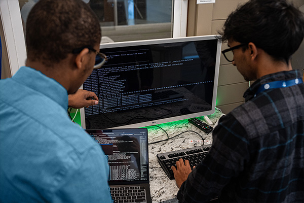 dsu student and professor working on computer coding in madlabs
