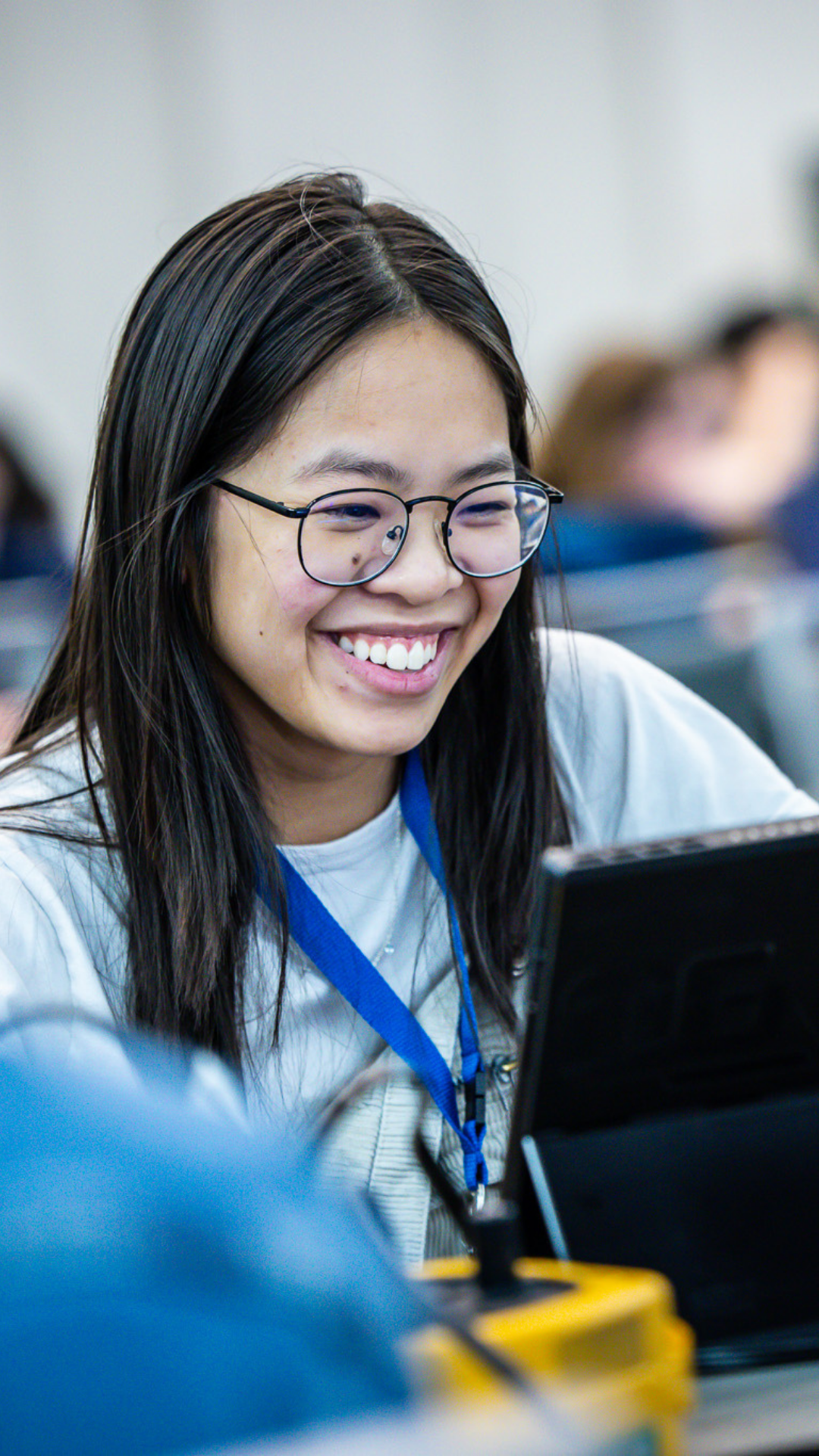 dsu student smiling working on computer at IEEE conference