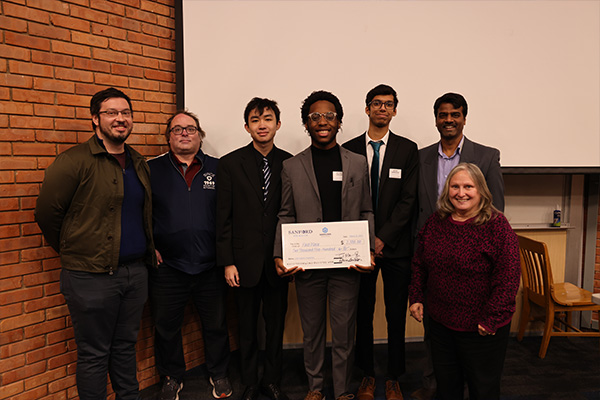 Data analytics students proudly displaying a prize from a competition.