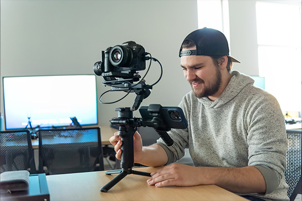 Digital content creation student lining up a shot on a camera rig.