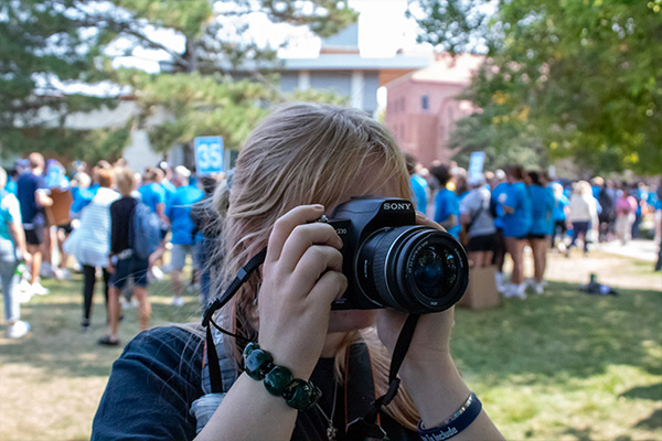 Digital photography student holding a camera up to take a photo.