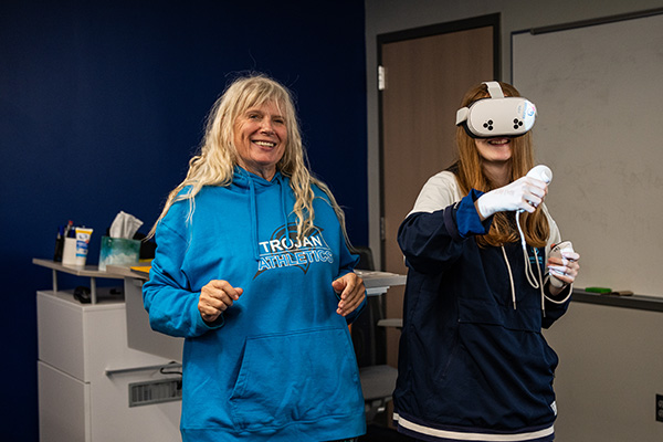 Education specialist working with a student who is wearing a VR headset.