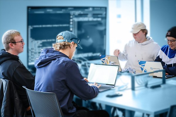 ethical hacking students working at laptops