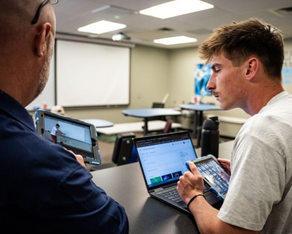 exercise science student reviewing work on ipad with professor