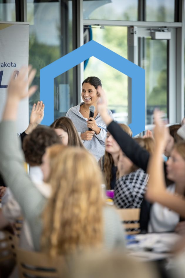 student smiling at crowd at FBLA meeting