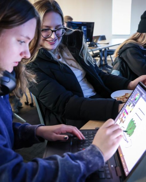 game design students working on laptop at global game jam