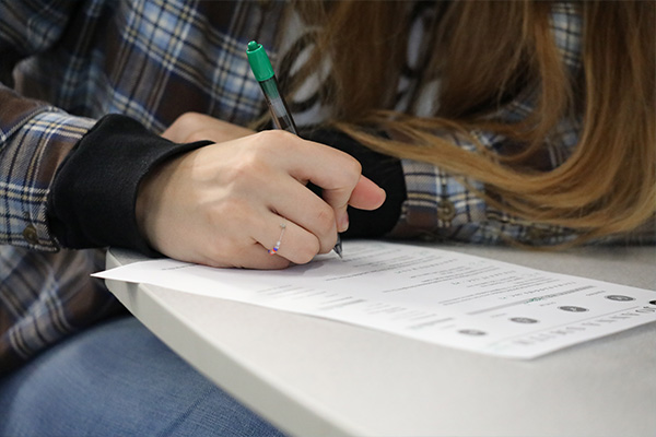 student writing on a paper