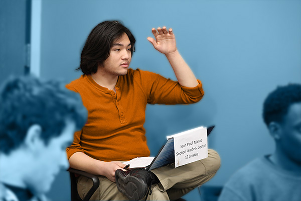 History student raising hand in class
