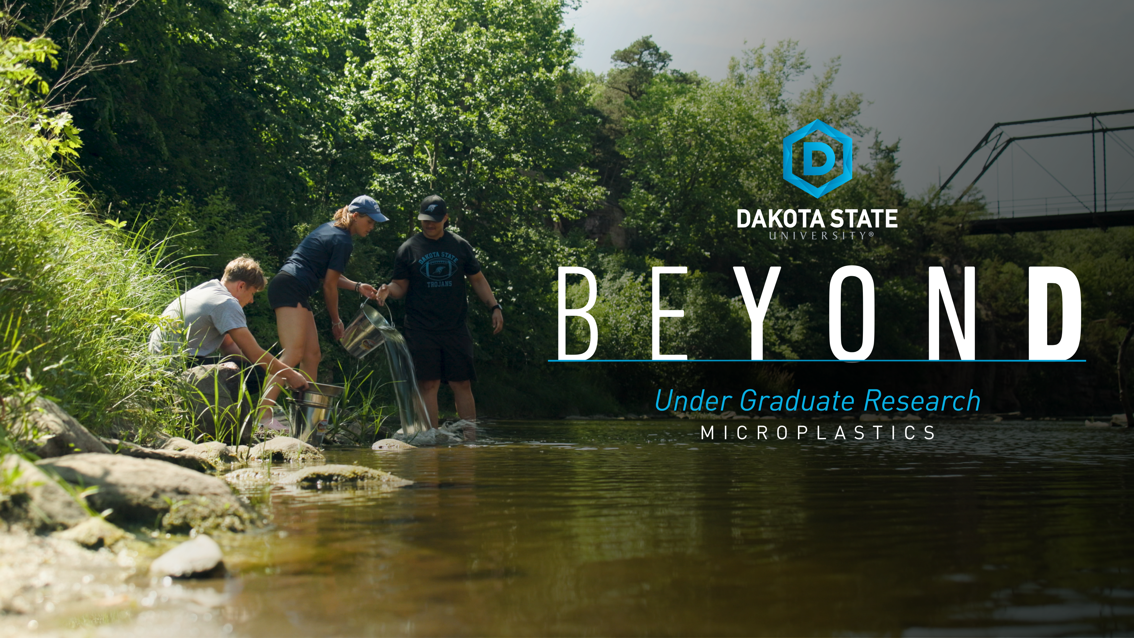 Thumbnail for video showing DSU students standing in a river empting a metal pail of water. The text reads Beyond undergraduate research microplastics.