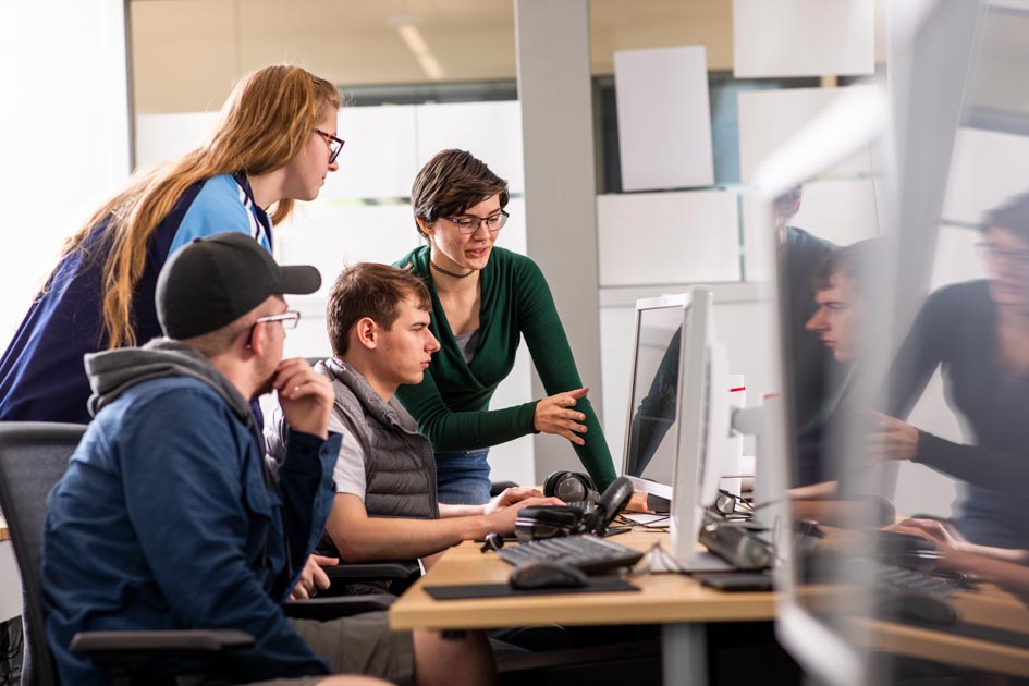 Research students gathered around a computer.