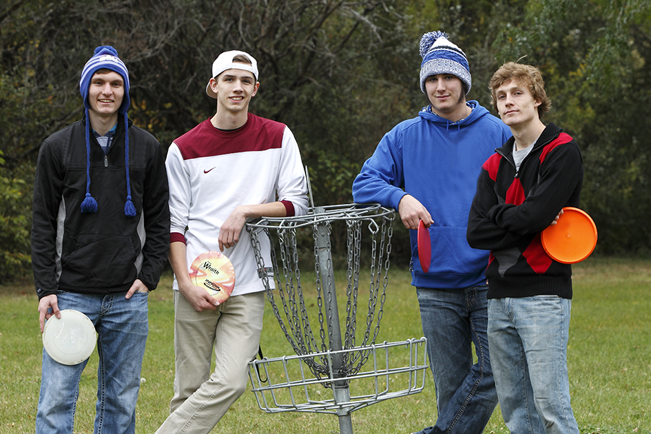 students standing by frisbee golf goal