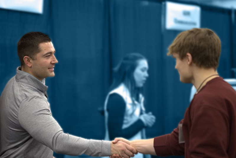 A DSU student shaking hands with a potential employer thanks to the support of the career and professional development office. 