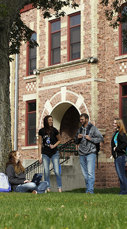 students standing in front of campus building