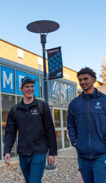 students standing in front of campus building