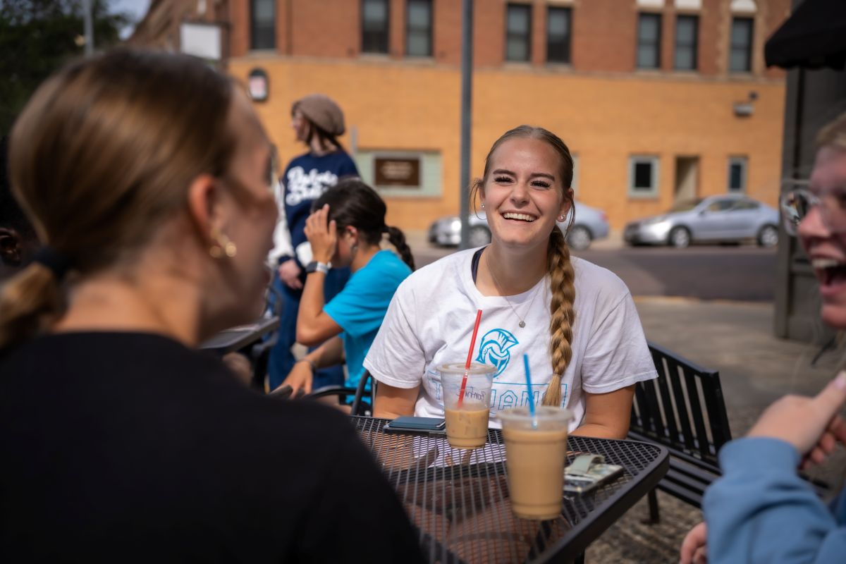 dsu students sitting outside at a table in downtown madison