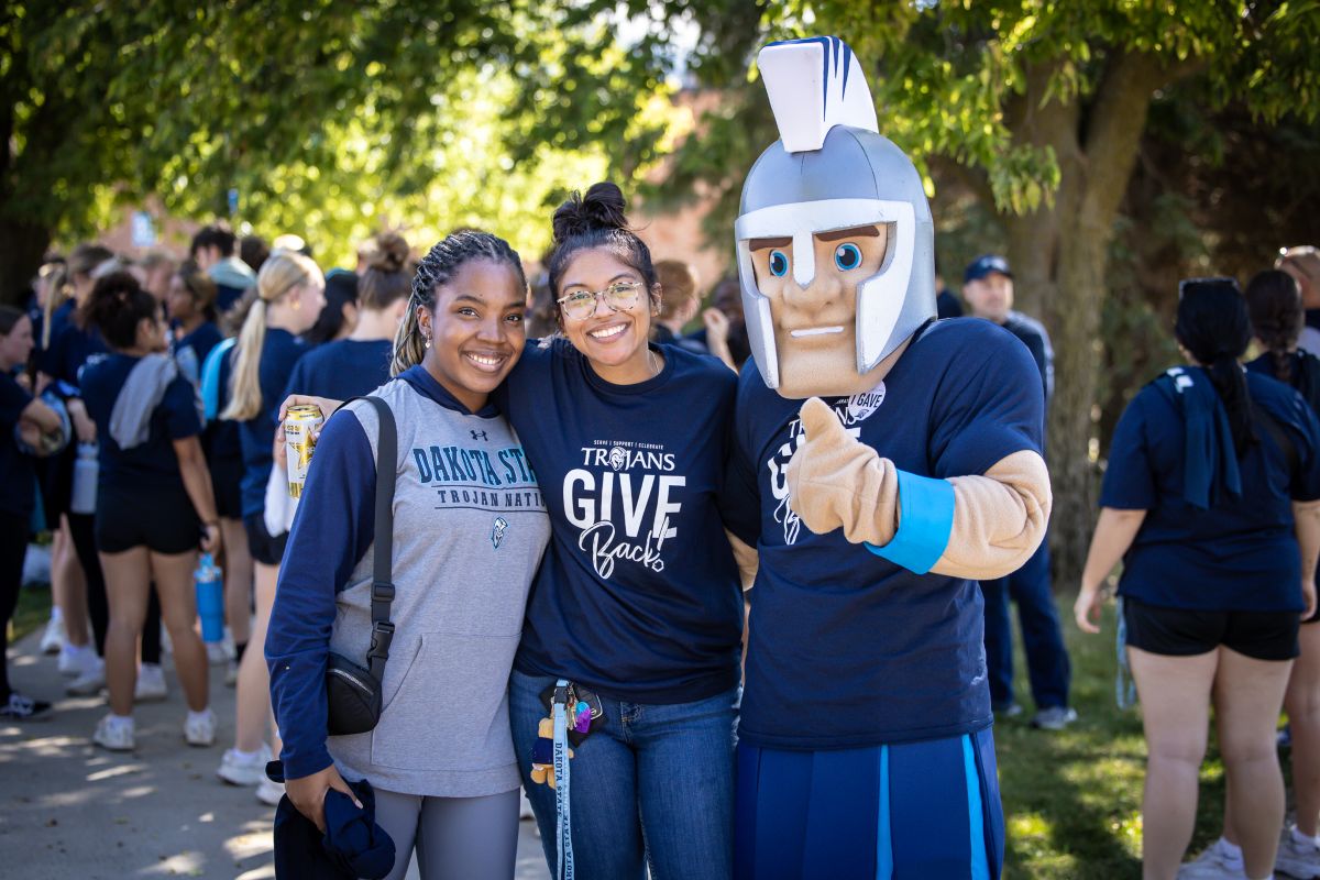 two dsu students with general cy at trojans give back