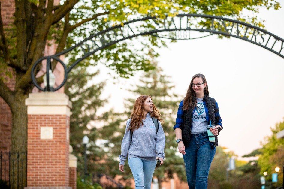 Dakota State University students talking together under the arch on campus