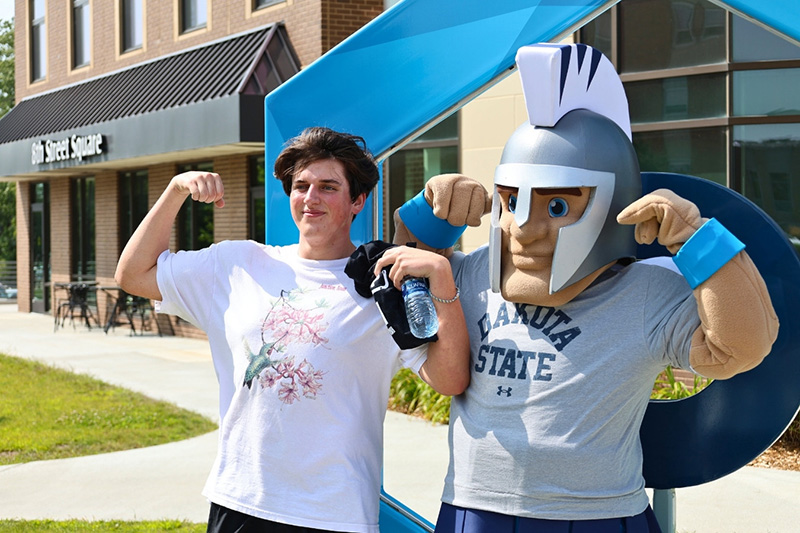 Student flexing with mascot